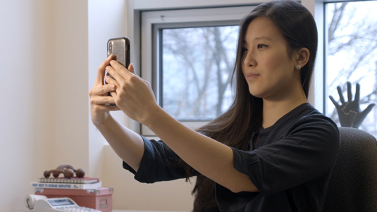 Woman taking a live selfie photo with her phone.